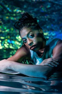 A futuristic African young woman is portrayed in a vibrant, digital environment, symbolizing the