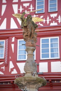 Justice with wing, beam scale and sword as a symbol of justice, stone sculpture, half-timbered,