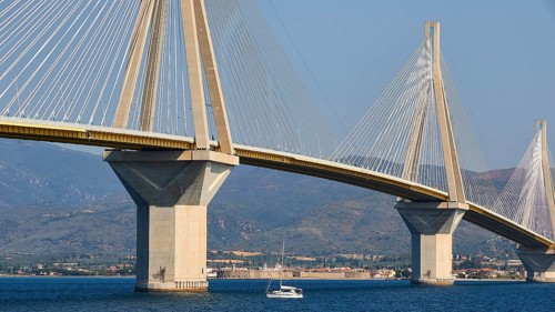 Close-up of a bridge with steel cables and a boat on the water, Rio-Antirrio cable car bridge,