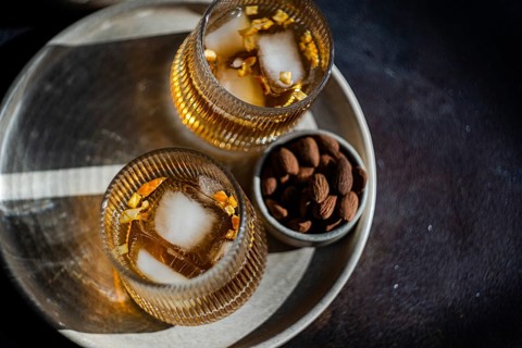 Top view of two spiced cognac-based cocktails with cinnamon and star anise, served alongside a bowl