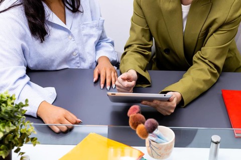 Two professionals engaged in an image consulting session, seated at a table, discussing strategies