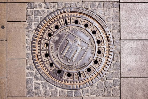 Manhole cover, state capital Munich, city drainage works, Münchner Kindl city coat of arms, walkway