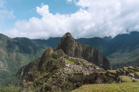 Stunning view of the iconic Machu Picchu ruins set against a backdrop of lush green mountains in