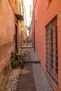 View through a picturesque narrow alley of the medieval old town of Cervo, province of Imperia,