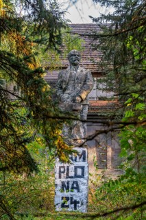 Statue of Vladimir Ilyich Lenin in front of the ruins of the Officers' House, officers' mess at the