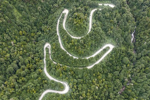 Aerial view of a winding road (Carretera Austral) through dense forest, south of Puyuhuapi, Aysén