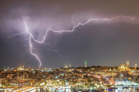 A stunning long-exposure photograph featuring a vivid display of lightning illuminating the night