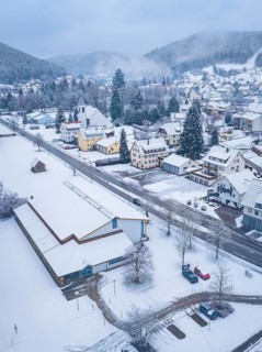 Snow-covered streets and houses of a village in wintry mountains. The scenery looks peaceful and