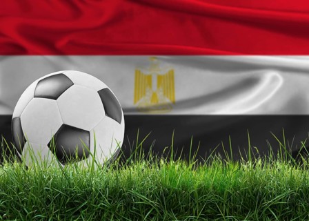 Soccer ball on pitch against Egyptian flag in the background. Soccer ball on the grass with Egypt