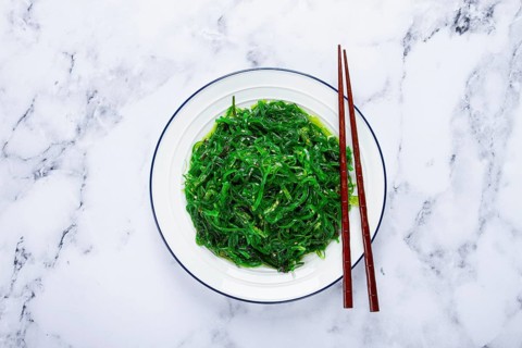 Chuka salad, made from fresh seaweed, with sesame dressing, served on a white plate, with