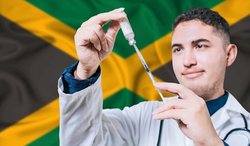Doctor holding syringe on Jamaica flag background. Medical professional holding syringe with