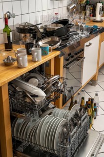 Kitchen after a big dinner, cooking party, dishwasher, full, with cleaned dishes, dirty glasses,