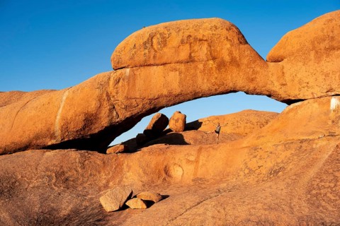 Morning, woman standing in rock arch, Pontok Mountains, Große Spitzkoppe, Spitzkoppe, Große