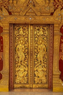 Door with golden reliefs of the Buddhist temple Wat Xieng Thong Luang Prabang, Laos