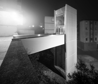 A mysterious black and white photo capturing an urban elevator surrounded by dense mist, set