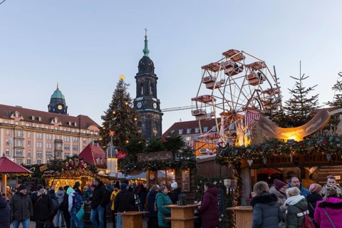 Christmas market Striezelmarkt on the Altmarkt with Kreuzkirche tower and Ferris wheel, Dresden,