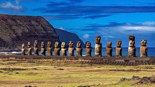 Moai statues along a grassy coastline with rolling landscape in the background, The Moai statues on