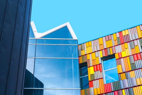 A contemporary building with a vibrant, multicolored facade contrasts sharply against a striking