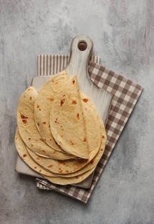 A stack of Mexican tortillas, on a gray table, top view, close-up, no people