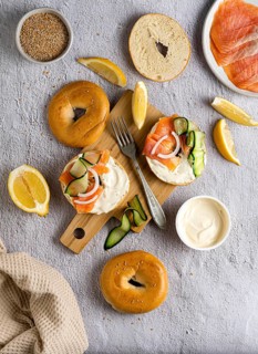 A delicious brunch setup featuring fresh bagels topped with smoked salmon, cucumber, and cream