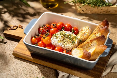 Delicious baked Camembert cheese paired with roasted cherry tomatoes and crusty bread, garnished