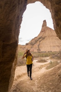 Vertical photo of a woman strolling between rocky formations in a desert natural park