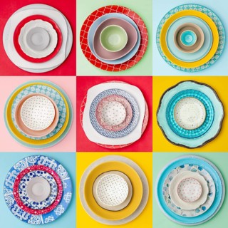 A colorful, overhead view of nine diverse plate arrangements. Each set features unique patterns and