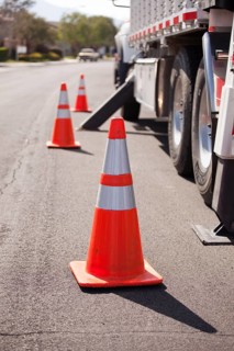 Several Orange Hazard Cones and Utility Truck in Street