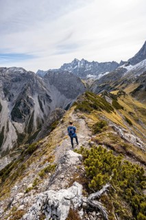 Mountaineer on a hiking trail on the ridge of Hahnkampl, mountain panorama with rocky steep peaks,