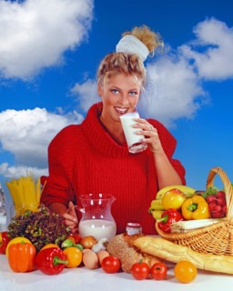 Young blonde woman eating a yoghurt for breakfast, Studio