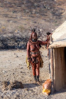 Married Himba woman leaning against a traditional mud house, traditional Himba village, Kaokoveld,