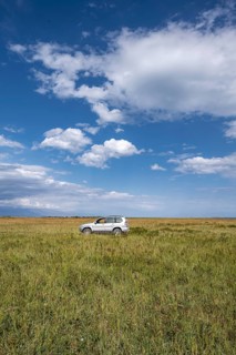 Car in open grassland under a wide sky, Yssykköl, Kyrgyzstan