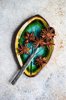 Top view of star anise beautifully arranged on a ceramic dish with vibrant green and yellow tones