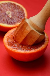 Halved blood orange with citrus squeezer, orange
