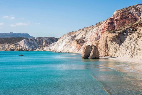 The stunning coastline of Milos Island, with crystal-clear turquoise waters, dramatic rocky cliffs,