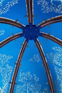 Close-up of backlit blue tinted plexiglass and curved wood panels canopy decorated with white maple