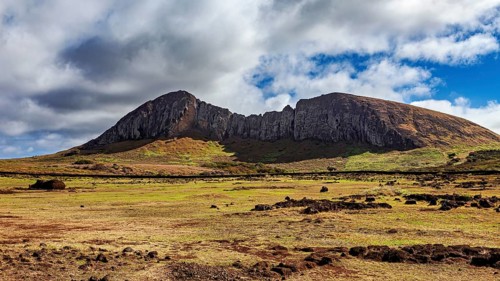 Distinctive rock formation rises under clouds in a vast landscape, the landscape of Easter Island