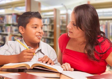 Hispanic Young Boy and Famle Adult Studying At Library