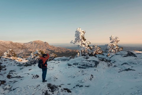 A breathtaking winter scene at Siete Picos, Guadarrama Mountains, Madrid. A hiker stands amidst
