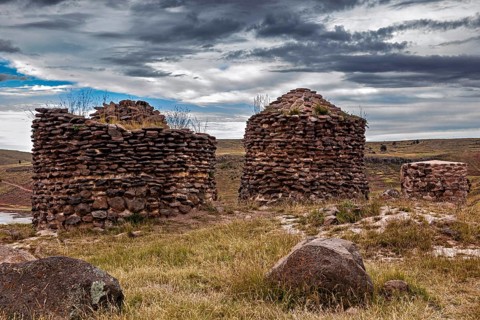 Two old stone towers on a grassy area, The Chullpas of Sillustani near Puno in Peru