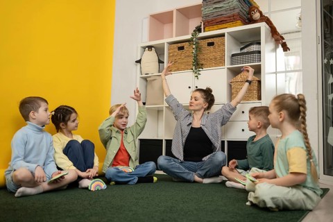 A teacher guides young children in a creative classroom activity, fostering imagination and