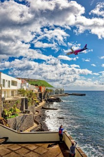 Aeroplane approaching Madeira airport, promenade on the Atlantic Ocean beach, municipality of Santa