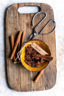 Top view of aromatic anise stars and cinnamon sticks arranged elegantly on a rustic wooden cutting