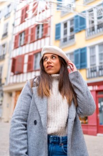 Vertical portrait of a beauty woman wearing beret and coat in the city