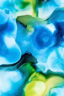 A vivid abstract pattern created by blending blue and green liquid inks. The mesmerizing swirls and