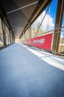 Modern footbridge with glass and metal structures on a sunny day, Hermann Hesse Bahn, ZOB, Calw,