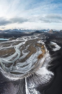 Aerial view of the Icelandic Highlands, featuring dramatic landscapes with winding rivers, rugged