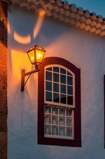 Window and facade of an old colonial-style house illuminated by a lantern at night in Tiradentes,