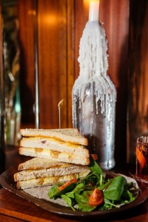 A deliciously stacked club sandwich filled with melted cheese and caramelized onions, served with a