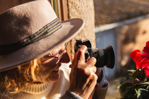 In a serene countryside home in Barcelona, Spain, a senior woman captures the beauty of the